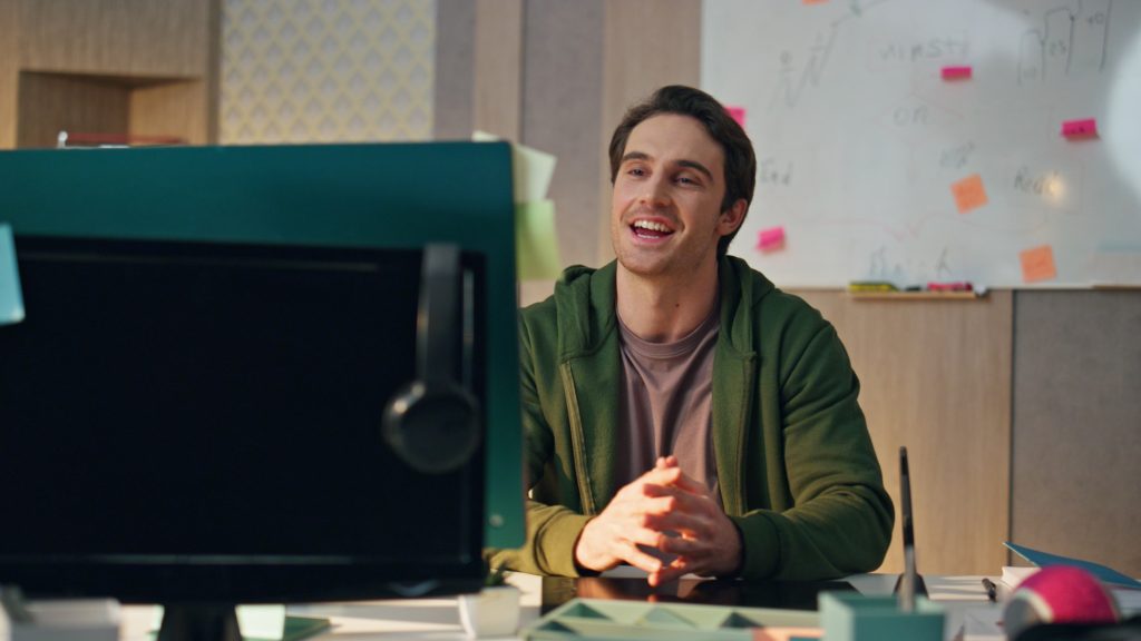 Friendly creator greeting computer videocall at office. Smiling guy waving hand
